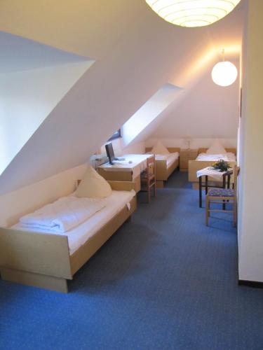 um quarto com uma cama e mesas num sótão em Haus Annaberg em Bona