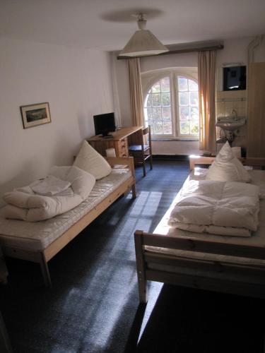 2 camas en una habitación con ventana en Haus Annaberg en Bonn