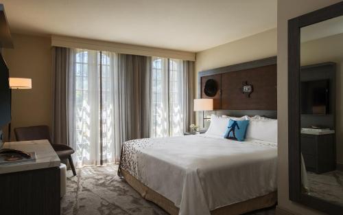 a hotel room with a bed with a blue bow on it at Casa De Palmas, Trademark Collection by Wyndham in McAllen
