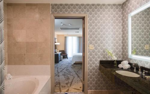 a bathroom with a tub and a sink at Casa De Palmas, Trademark Collection by Wyndham in McAllen