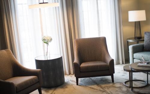 a room with two chairs and a table with a vase of flowers at Casa De Palmas, Trademark Collection by Wyndham in McAllen