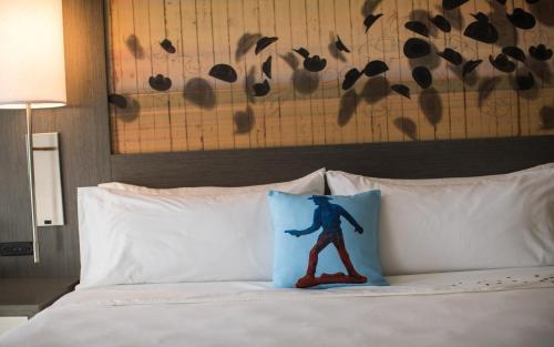a pillow with a man on it sitting on a bed at Casa De Palmas, Trademark Collection by Wyndham in McAllen