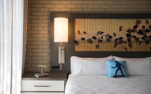 a bedroom with a bed with a blue pillow on it at Casa De Palmas, Trademark Collection by Wyndham in McAllen