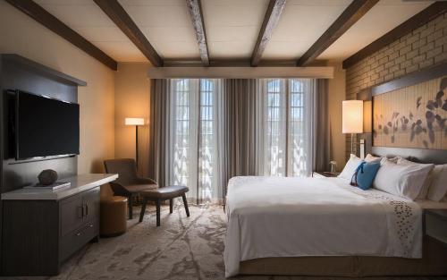 a hotel room with a bed and a flat screen tv at Casa De Palmas, Trademark Collection by Wyndham in McAllen