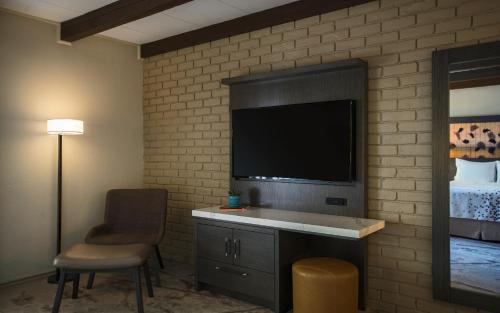 a living room with a tv on a brick wall at Casa De Palmas, Trademark Collection by Wyndham in McAllen