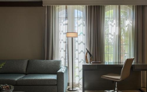 a living room with a couch and a desk next to a window at Casa De Palmas, Trademark Collection by Wyndham in McAllen