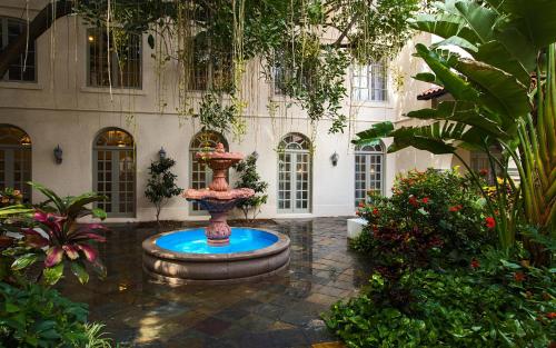 a fountain in the middle of a courtyard with plants at Casa De Palmas, Trademark Collection by Wyndham in McAllen