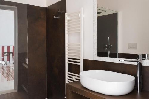a bathroom with a white sink and a mirror at D-Home Ortigia in Siracusa