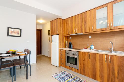 a kitchen with wooden cabinets and a dining table at George's House in Zekros