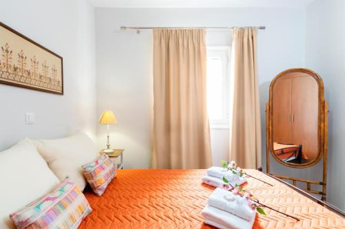 een slaapkamer met een bed met een spiegel en handdoeken bij George's House in Zakros