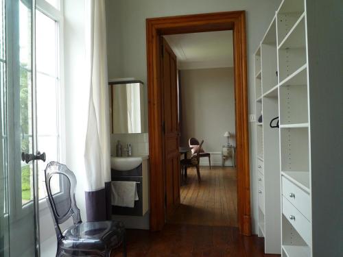 - un couloir avec une salle de bains pourvue d'un lavabo et d'un miroir dans l'établissement Château de Plessier-Roza, à Le Plessier-Rozainvillers