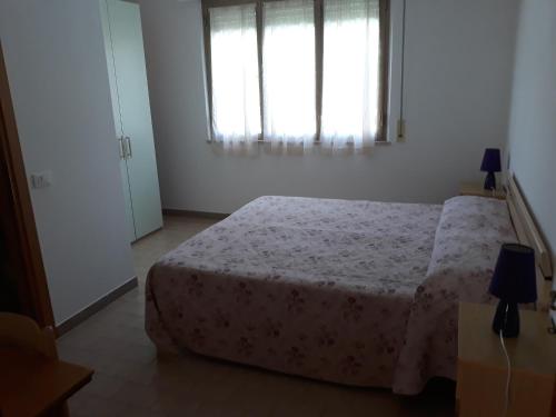 1 dormitorio con cama y ventana en Affittacamere FloraMare en Marina di Bibbona