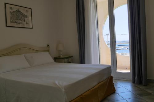 una camera da letto con un letto e una grande finestra di Hotel Celeste a Marzamemi