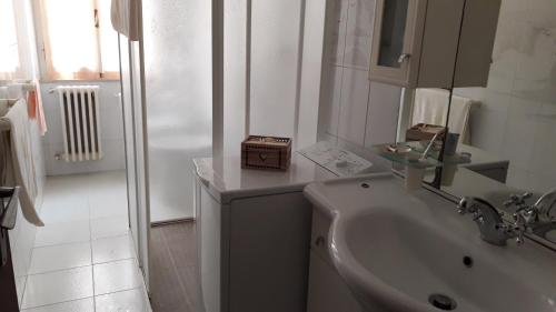 un bagno bianco con lavandino e WC di Un mare di relax a Follonica