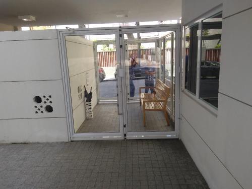 an open door to a patio with a cat sitting on a chair at Apartamento 2 quartos May Way Meireles uma quadra da Beira-mar in Fortaleza