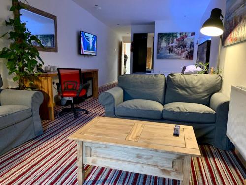 a living room with a couch and a coffee table at TheWaterfrontLodges in Coventry