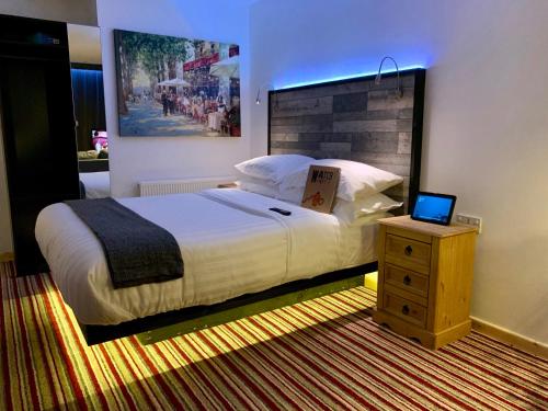 a bedroom with a bed and a laptop on a night stand at TheWaterfrontLodges in Coventry