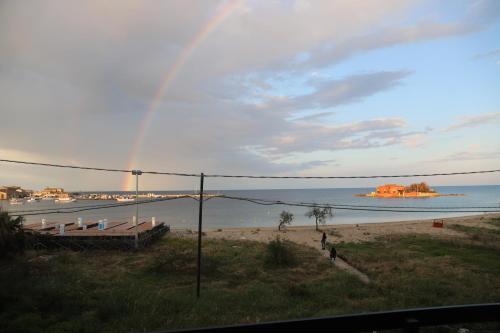 a rainbow over a beach with a boat in the water at Hotel Celeste in Marzamemi