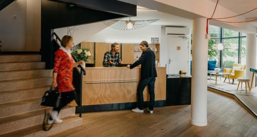 a man and a woman standing at a counter at Best Western Bridge Hotel Lyon East in Jons