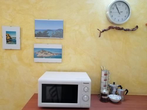 ラ・スペツィアにあるCa' de Spezaの電子レンジ(テーブル上、壁掛け時計付)