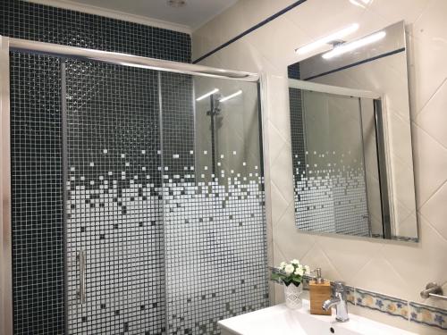 Un baño con ducha con lavabo y espejo. en Soul Surfer, en Peniche