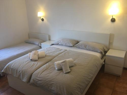 two beds in a room with towels on them at Albergo Ristorante Belcantone in Novaggio