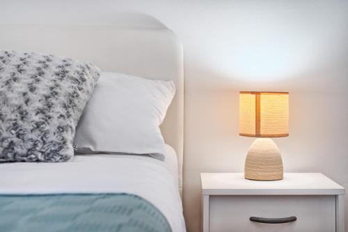 a bedroom with a bed and a lamp on a nightstand at Apartments Meštrović with heated swiming pool- near Split in Kaštela