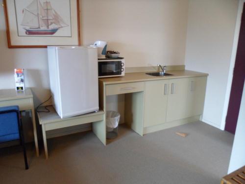 a small kitchen with a sink and a refrigerator at Essex Arms in Huntly