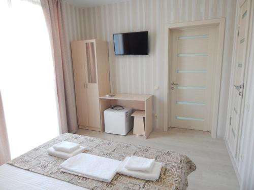 een slaapkamer met een bed met twee witte handdoeken erop bij Mantarini Hotel in Adler