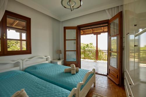 Villa Maria by RentalsPro - Ouranoupoli Halkidiki في أورانوبوليس: غرفة نوم مع سرير مع دمية دب عليها