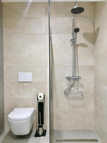 a bathroom with a toilet and a glass shower at Mediterranea Suite Apartment in Albir