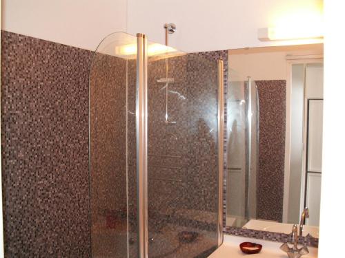 une douche avec une porte vitrée dans une salle de bain dans l'établissement Studio, à Bormes-les-Mimosas