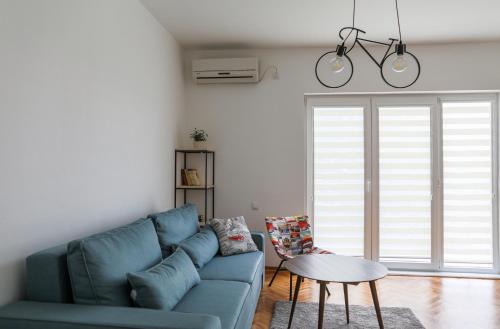 a living room with a blue couch and a table at Apartment Mihajlovic in Vranje