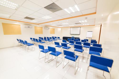 a conference room with chairs and tables and a podium at Hotel Elizabeth Central in Aguascalientes