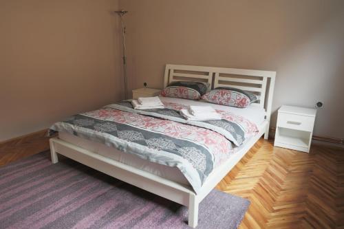 a bedroom with a white bed and a purple rug at Apartment Mihajlovic in Vranje