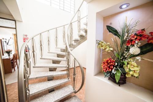 a staircase in a house with a vase of flowers at Hotel Elizabeth Central in Aguascalientes