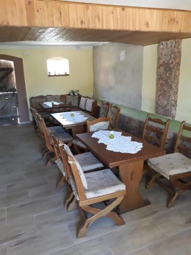 a dining room with wooden tables and chairs at Dworska Zagroda in Korytowo