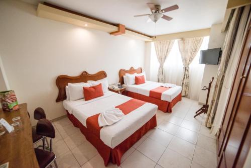 Habitación de hotel con 2 camas y ventilador de techo. en Hotel Elizabeth Central, en Aguascalientes