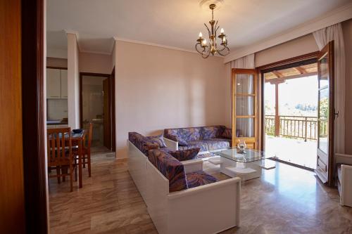 Villa Maria by RentalsPro - Ouranoupoli Halkidiki في أورانوبوليس: غرفة معيشة مع أريكة وطاولة