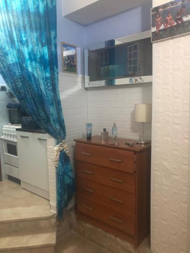 a kitchen with a wooden dresser and a blue curtain at Villa oasi in Fontane Bianche
