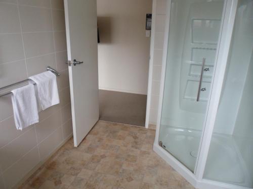 a bathroom with a shower and a glass door at Essex Arms in Huntly