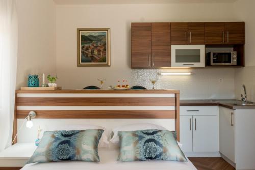 Apartments Stella del Mare في ريسان: غرفة نوم بسرير ومطبخ مع مايكرويف