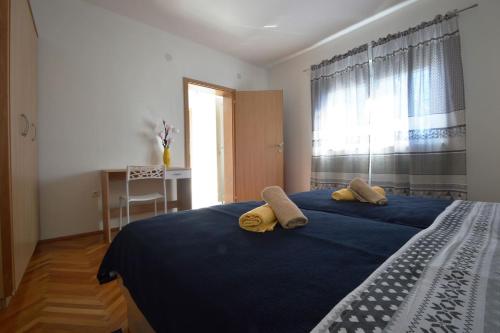 a bedroom with a blue bed with two towels on it at House Mia in Starigrad-Paklenica