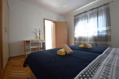 Un dormitorio con una cama azul con dos toallas encima. en House Mia, en Starigrad-Paklenica