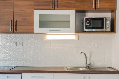 a kitchen with a sink and a microwave at Apartments Stella del Mare in Risan