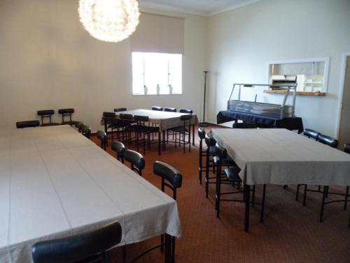 a room with tables and chairs and a chandelier at Essex Arms in Huntly