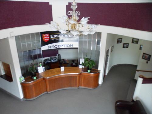 an office lobby with a reception desk and a chandelier at Essex Arms in Huntly