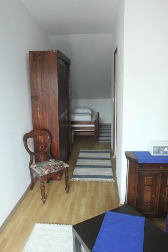 a room with a chair and a cabinet and a table at Dworska Zagroda in Korytowo