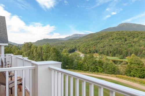 a white balcony with a view of mountains at The Glen House in Gorham