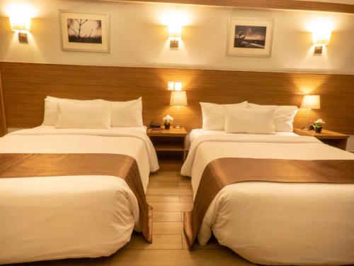 a hotel room with two beds and two lamps at Weston Suites Hotel in Santo Domingo